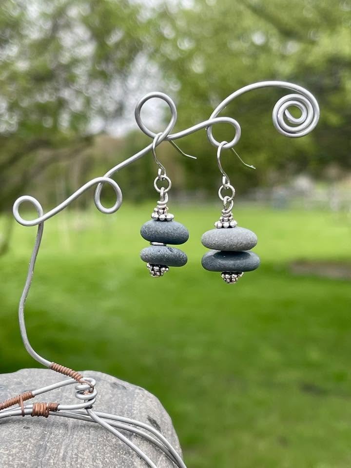 between the cedars rock earrings on a wire stand